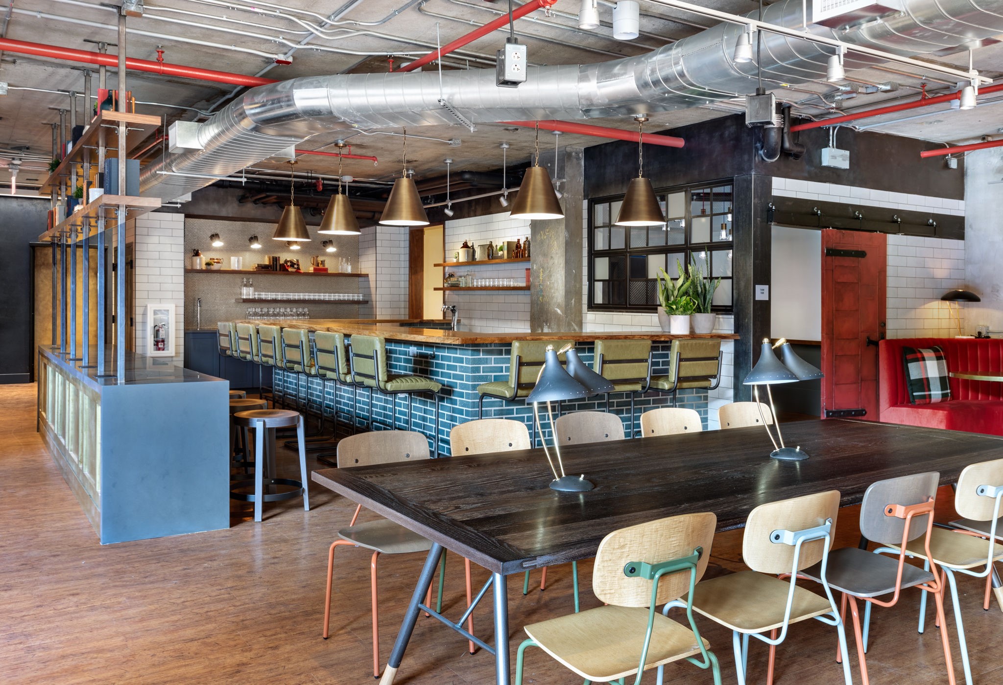 A large dining table with multiple chairs and a bar area in the background.