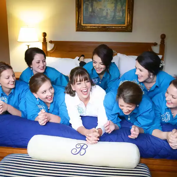 bridesmaids posing on bed with bride