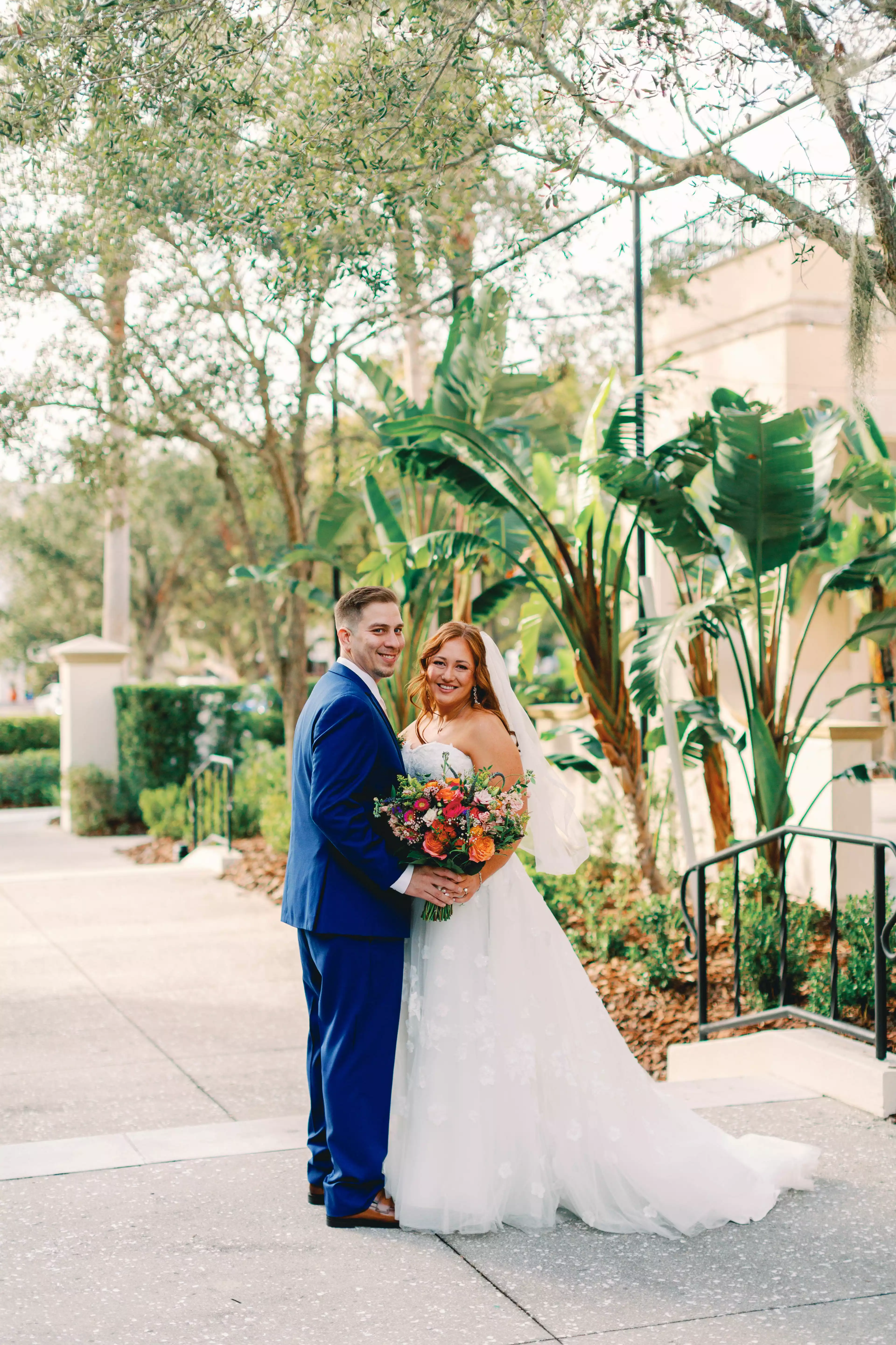 Bride and groom smiling at the camera at The Alfond Inn's Conservatory lawn