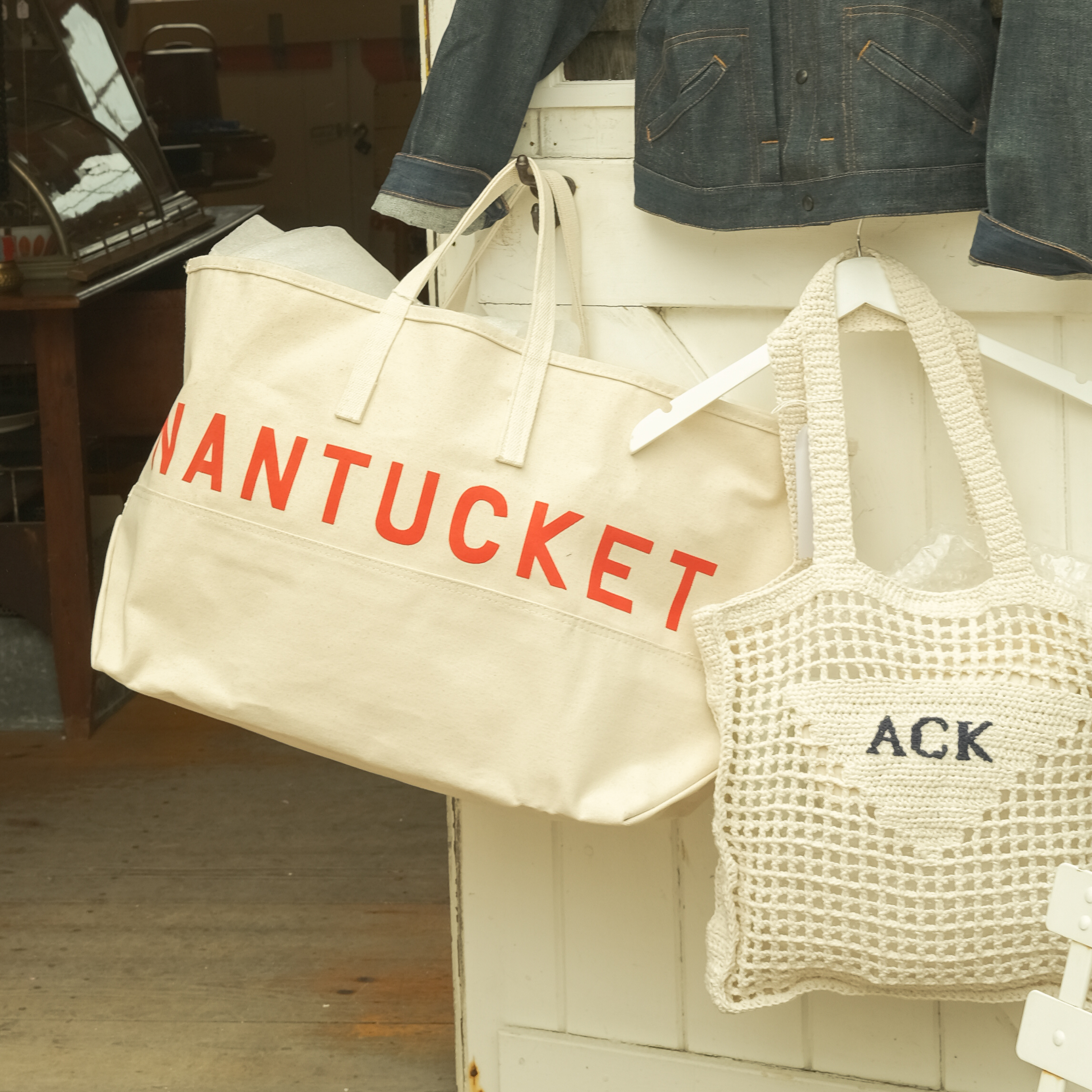 Pink flowers by a wooden fence overlooking boats in the ocean