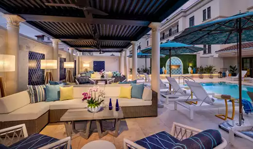 Seating area under pergola next to the outdoor pool