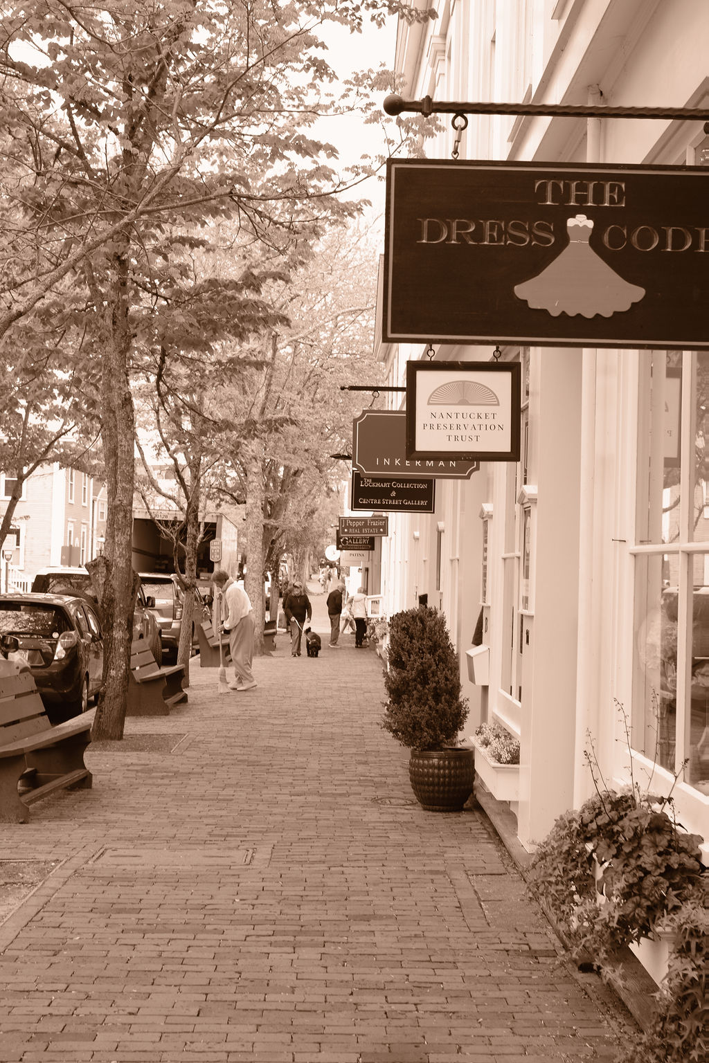 A view of store signs over a brick road in downtown Nantucket