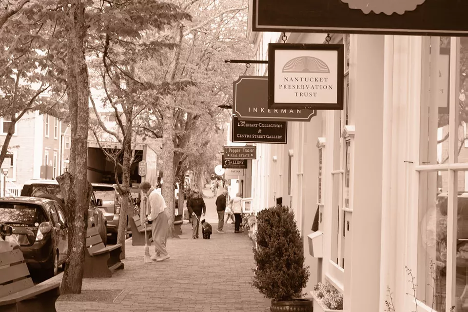 A view of store signs over a brick road in downtown Nantucket