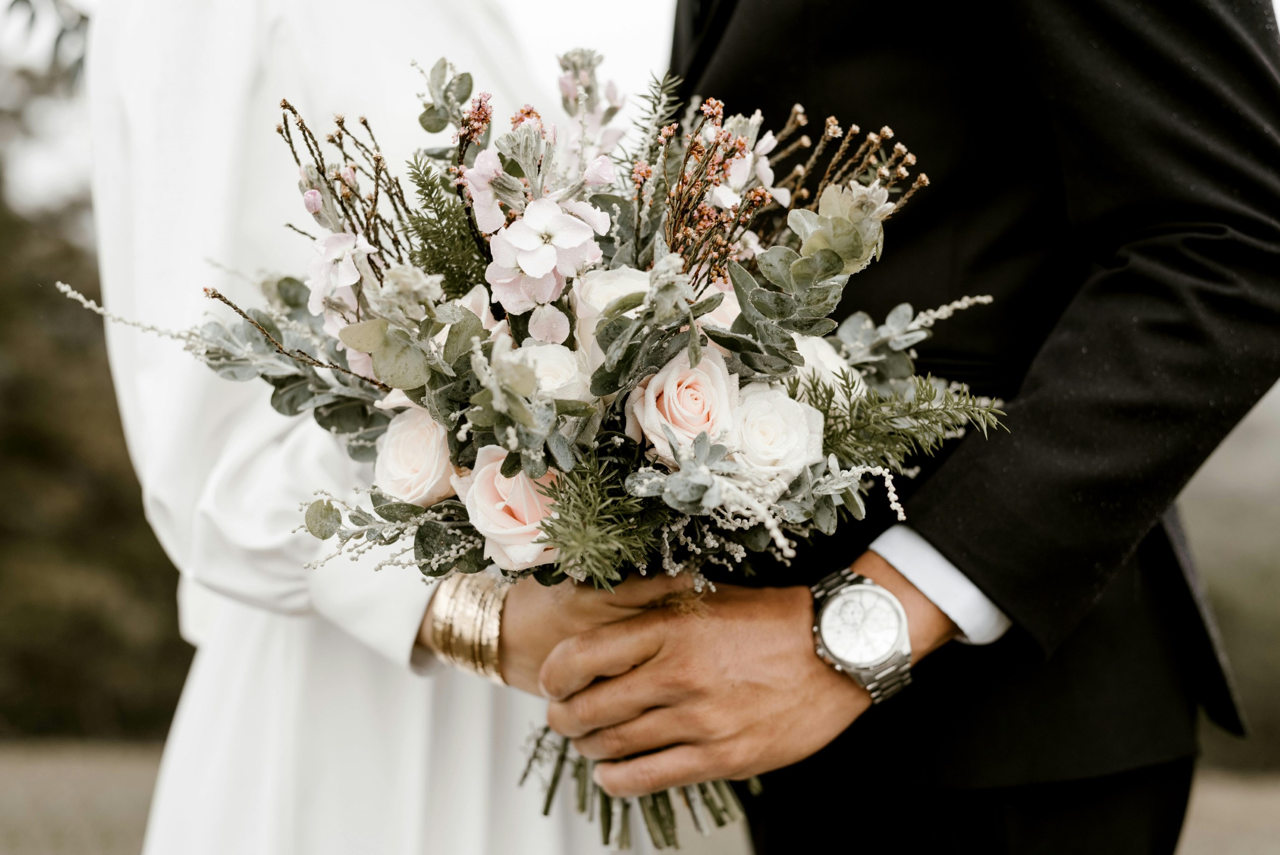 Bride and groom holding a bouquet of flowers on their wedding day