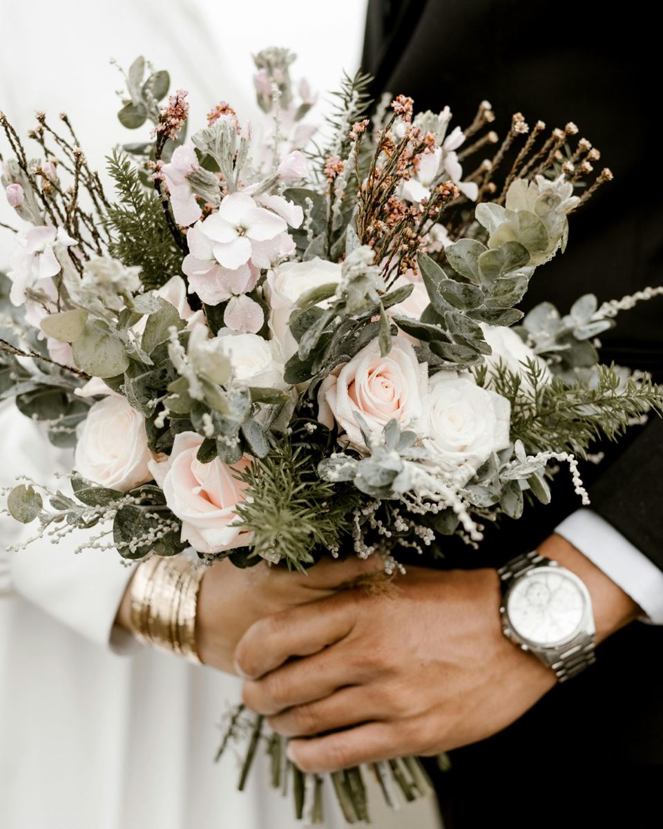 Bride and groom holding a bouquet of flowers on their wedding day