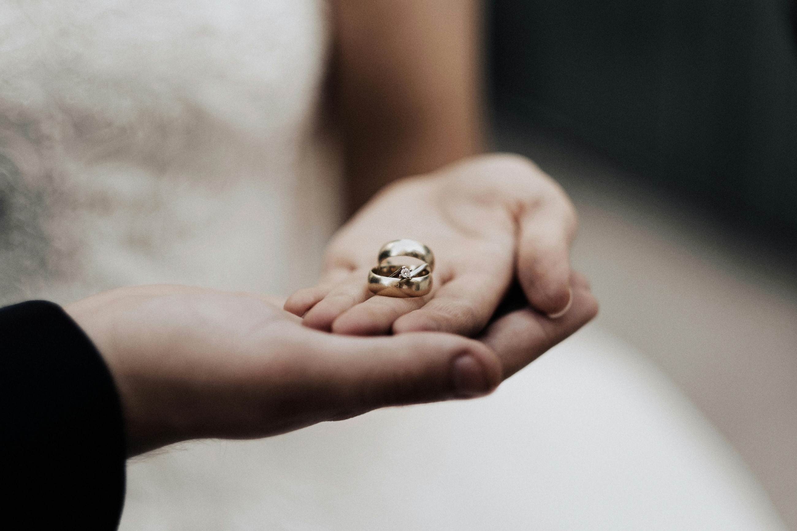 Bride and groom holding their wedding rings in their hands