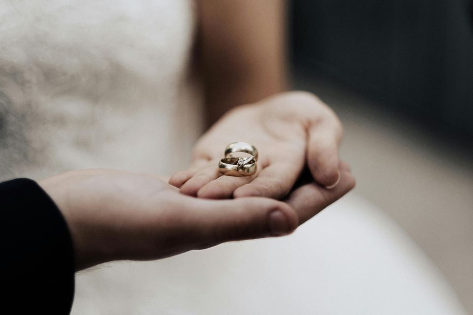 Bride and groom holding their wedding rings in their hands